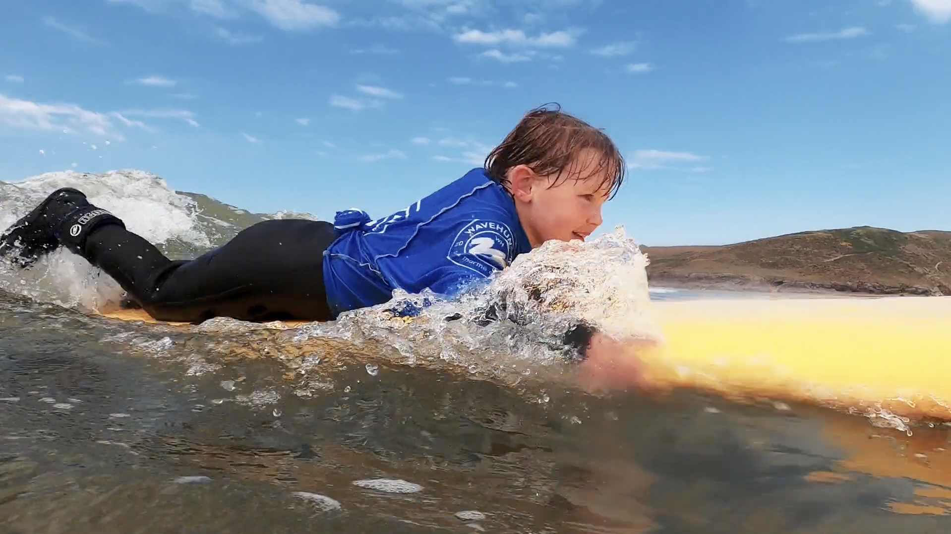 Child surfing at Polzeath Beach