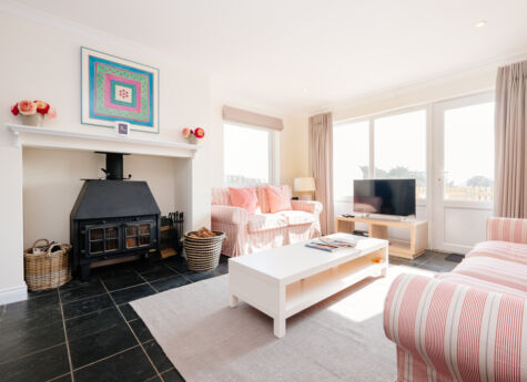 Highcliffe Holidays' stylish Nantucket cottage sitting room with a log-burning stove.